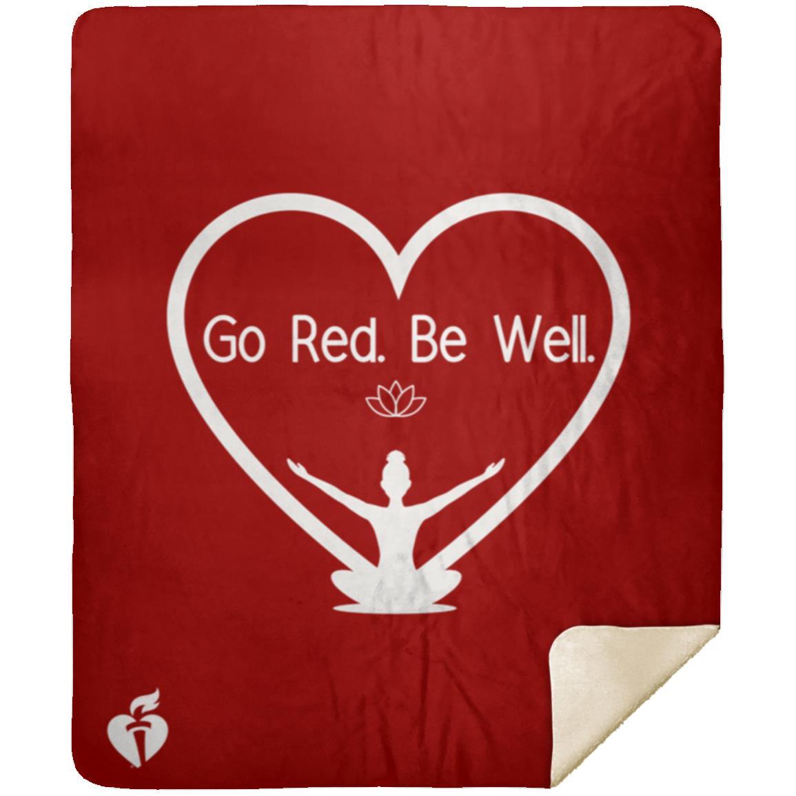 sherpa blanket with Go Red. Be Well. design on front (words inside a heart and woman in yoga post at bottom of heart). AHA heart and torch logo on bottom left corner.