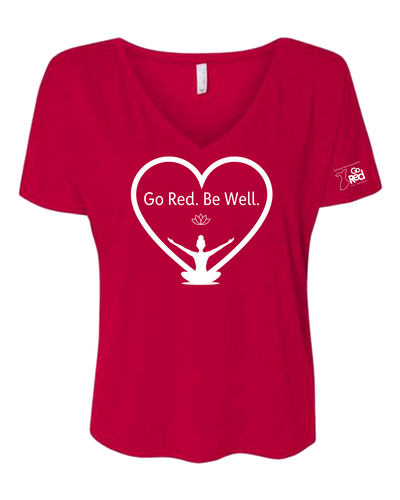 Red V-neck shirt with a white heart outline with "Go Red. Be Well." text featured inside along with a lotus and yogi icon. GRfW logo on left sleeve.
