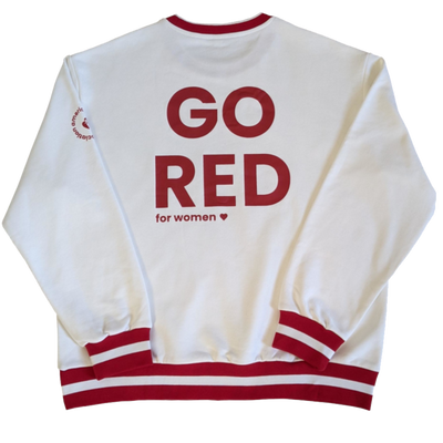 Back of white sweatshirt features large letters saying GO RED for WOMEN. neck and cuffs have red stripes for a varsity look.