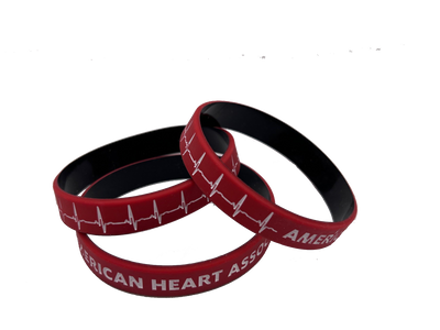 stack of 3 wristbands, red with black on inside. Printed on outside with white EKG line and "American Heart Association"