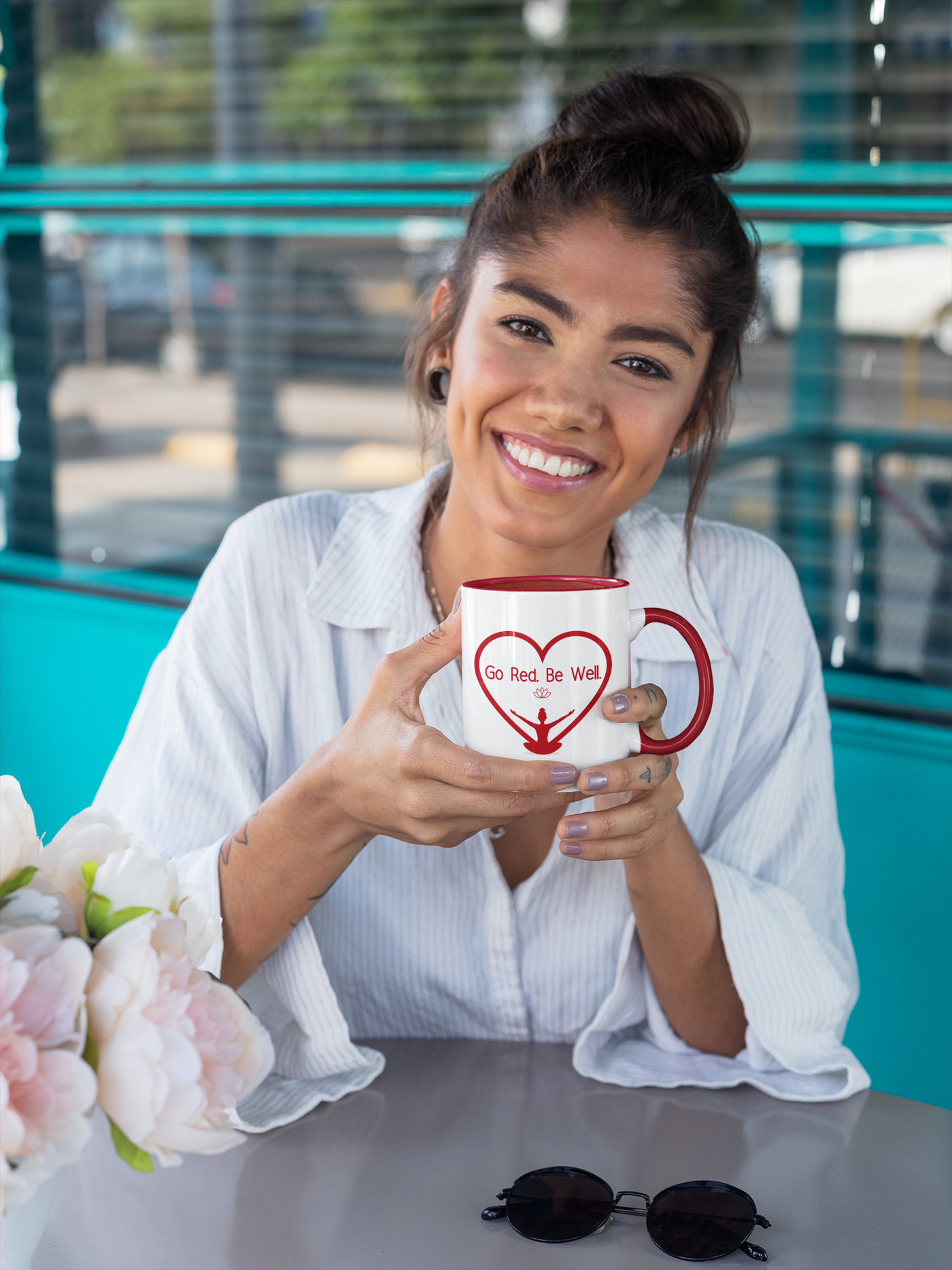 woman holding white mug with red handle and inside, and Go Red. Be Well. art on the side.